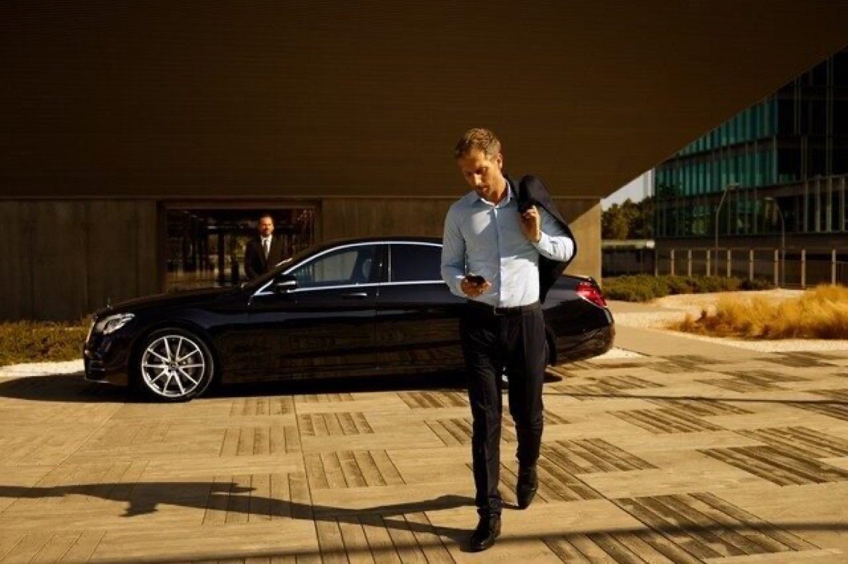 Luxury private chauffeur vehicle staged curbside for an executive departure in Arizona